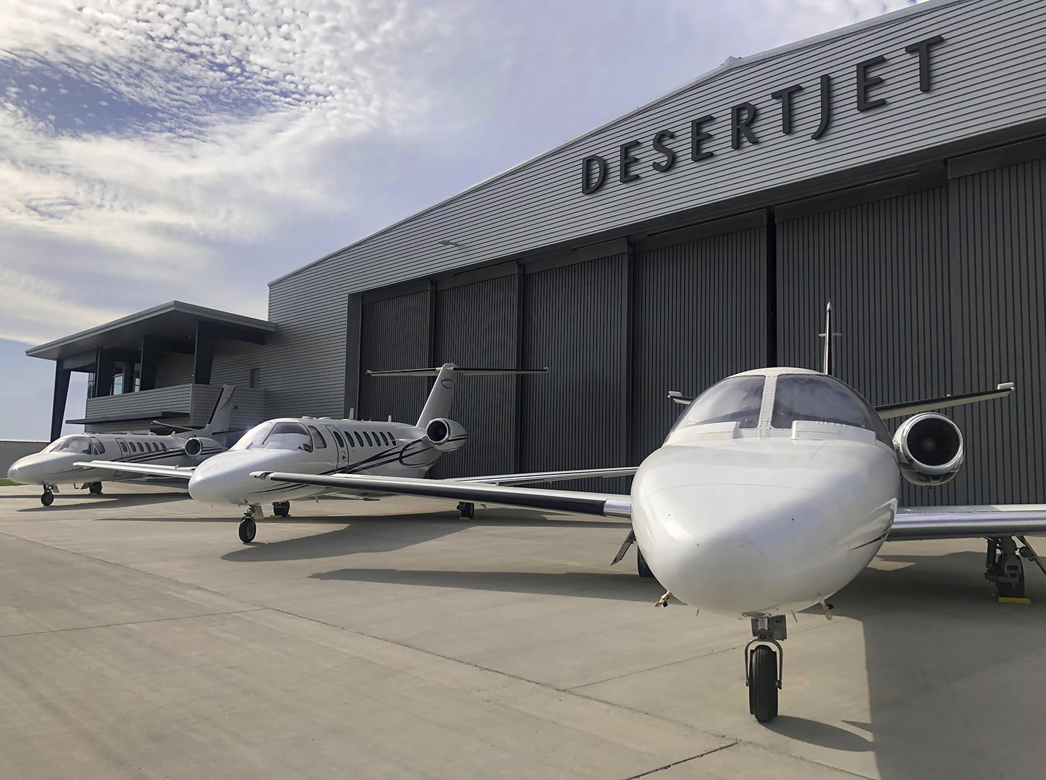 view of 3 aircraft in front of hanhar at Desert Jet